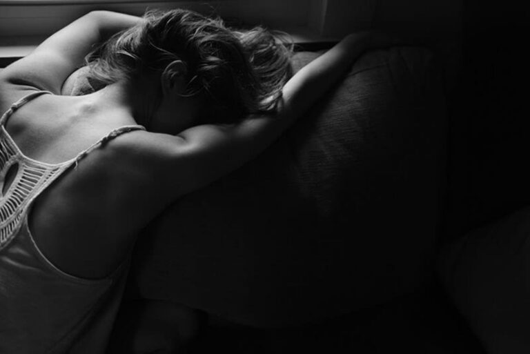 the woman is lying on the bed