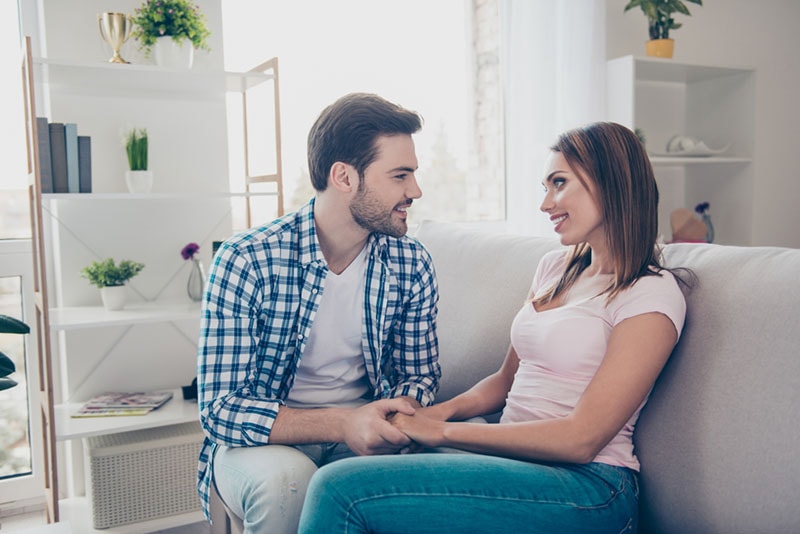 casal feliz a conversar no sofá