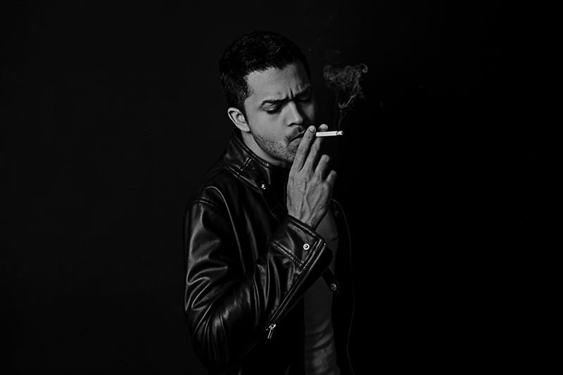 Man in leather jacket smoking cigarette 