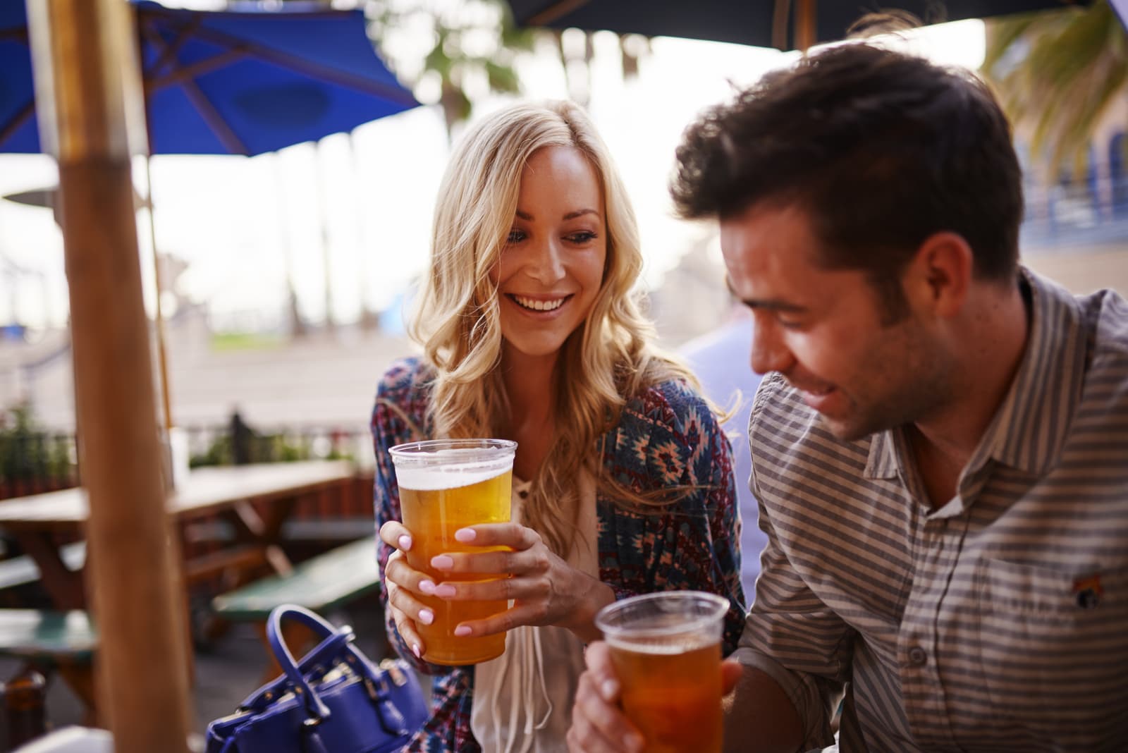romantic couple drinking beer at outdoor restaurant