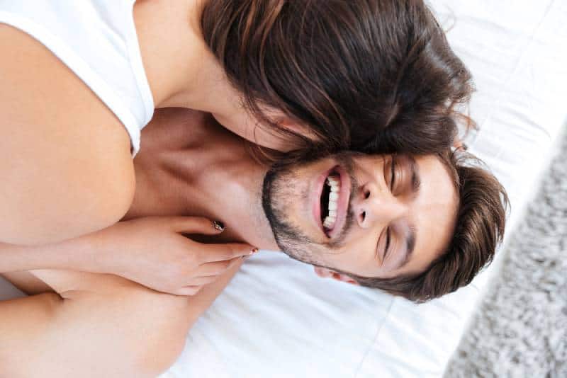 Close-up portrait of a young laughing couple in bed at home