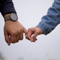 closeup photo man and woman holding pinky fingers