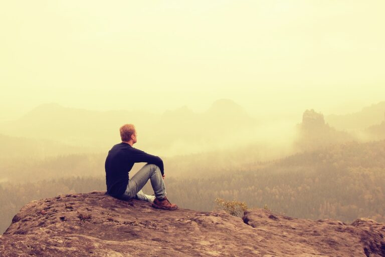 the man sits alone on the ground