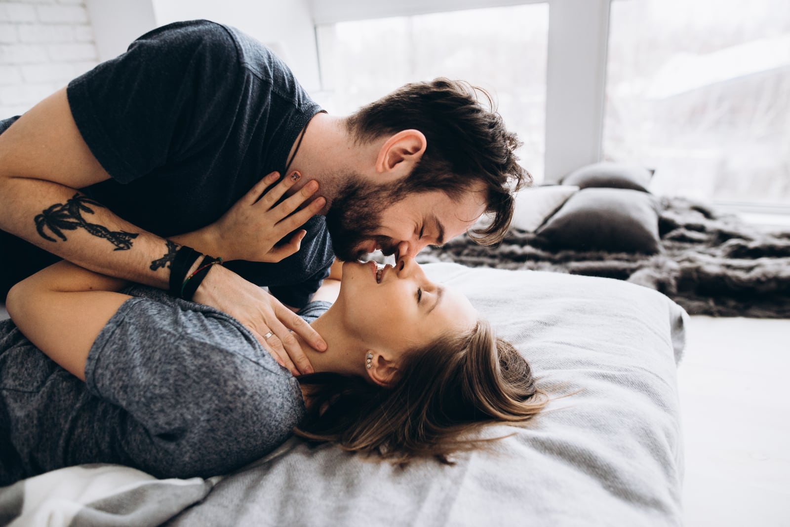 couple hugging and kissing on the bed