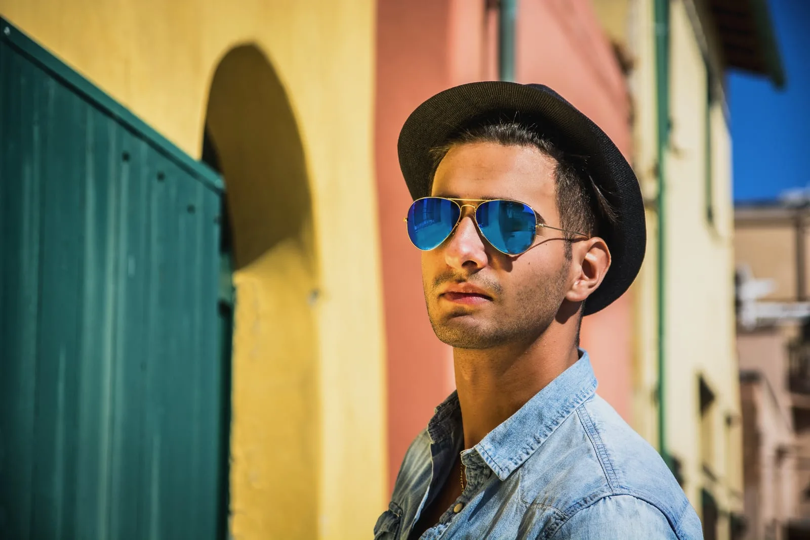dark haired young man wearing blue sunglasses