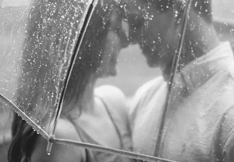 Happy couple under an umbrella on rain
