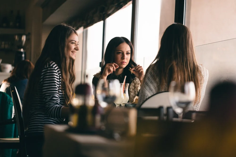 three friends are sitting in a cafe and talking
