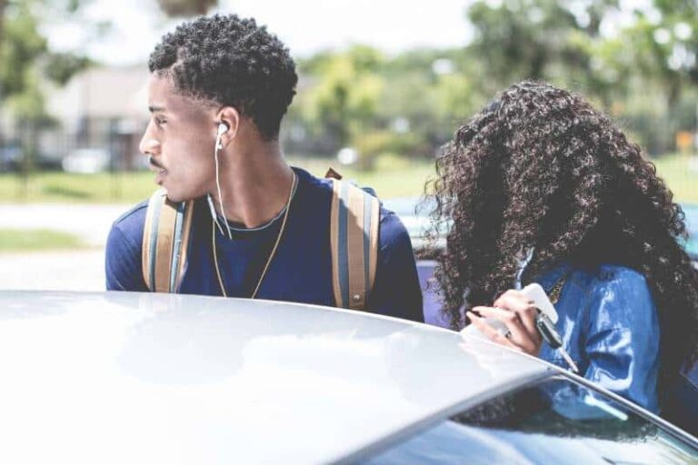 man wearing earbuds standing beside woman