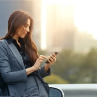 Business Woman Uses Smartphone