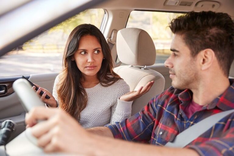 serious woman talking to man in the car