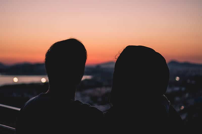 Man and woman on balcony watching the sunset