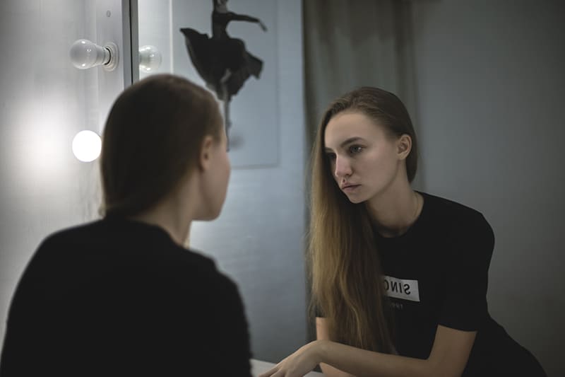 Young woman looking at the mirror