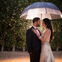 groom and bride under umbrella