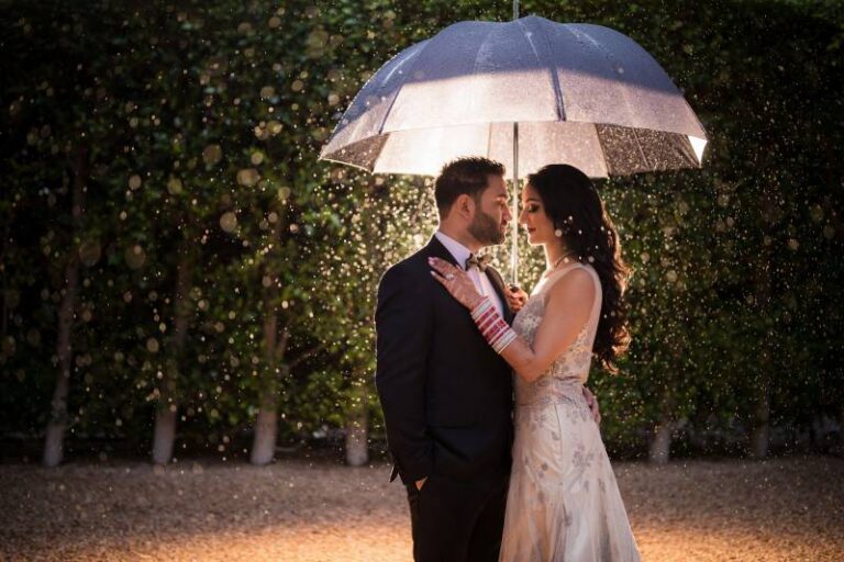 groom and bride under umbrella