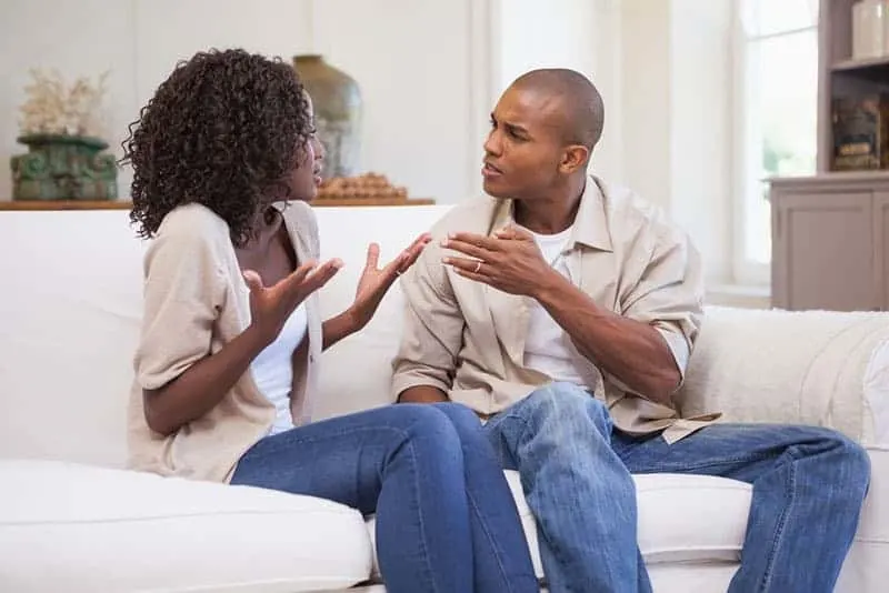 Unhappy couple arguing on the couch at home in the living room