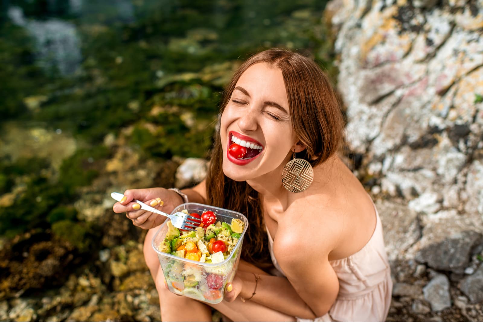 Woman eating healthy salad from plastic container