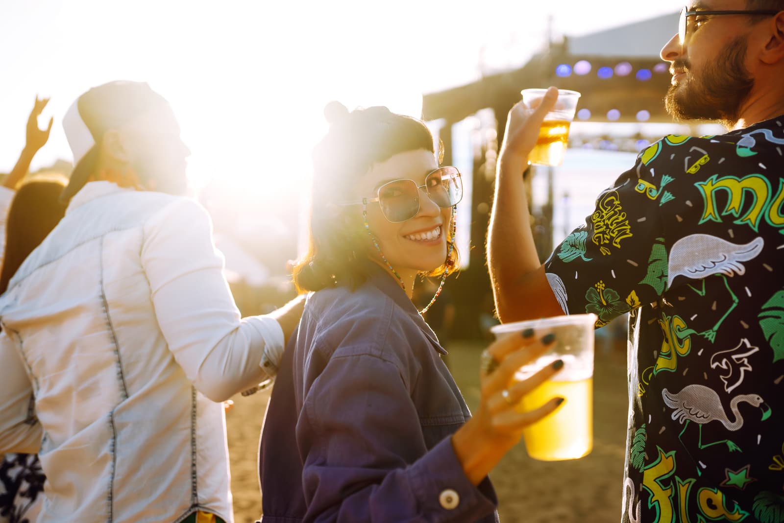 Young happy friends drinking beer and having fun at music festival