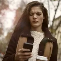 a gloomy woman holds a phone in her hand