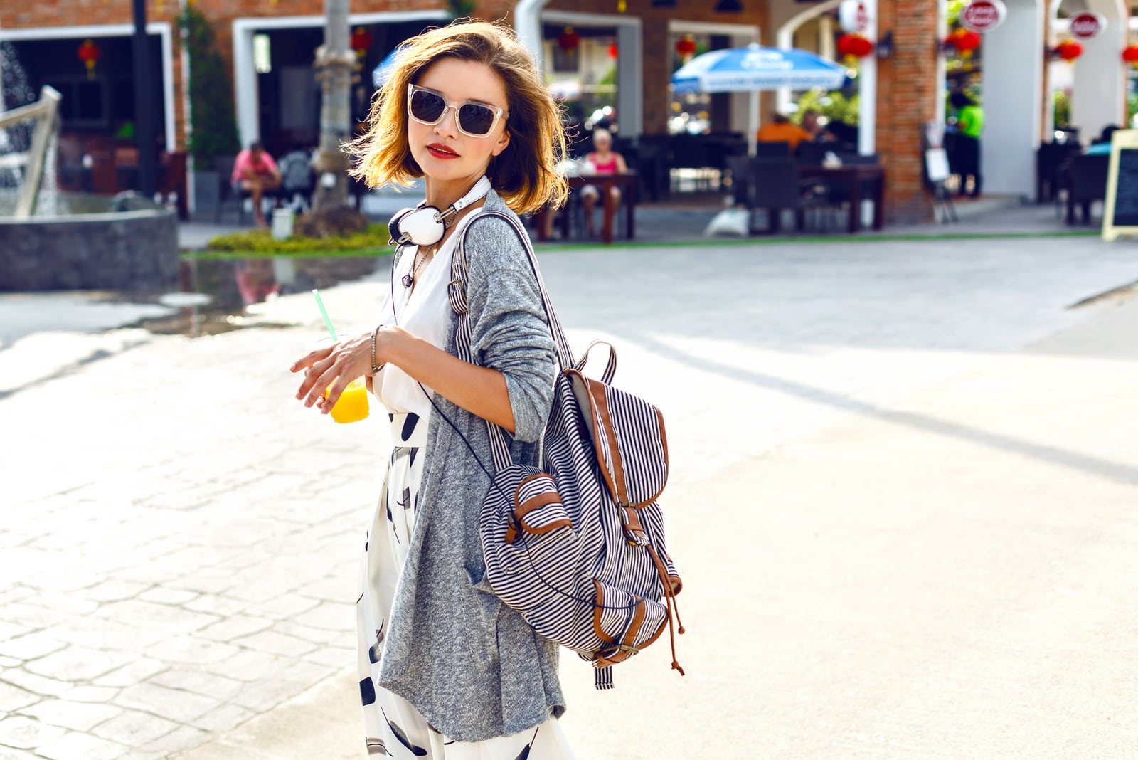 a woman with short brown hair walks down the street