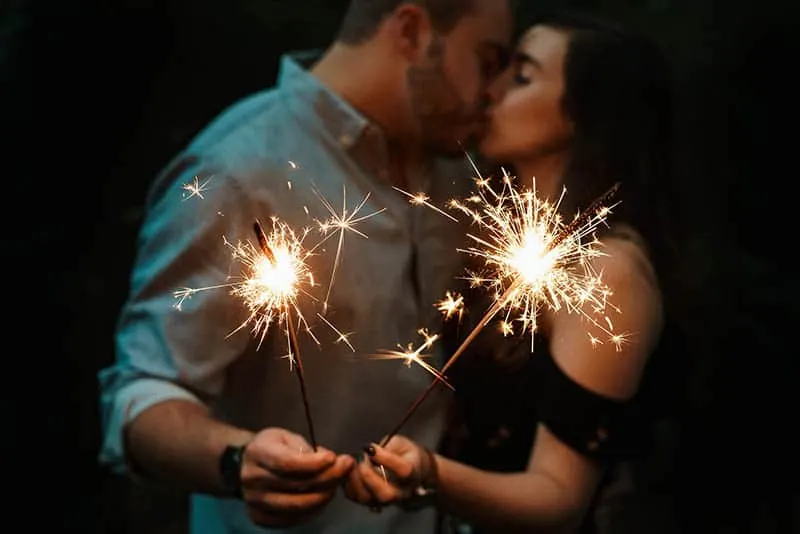 Couple kissing with sparklers in their hands