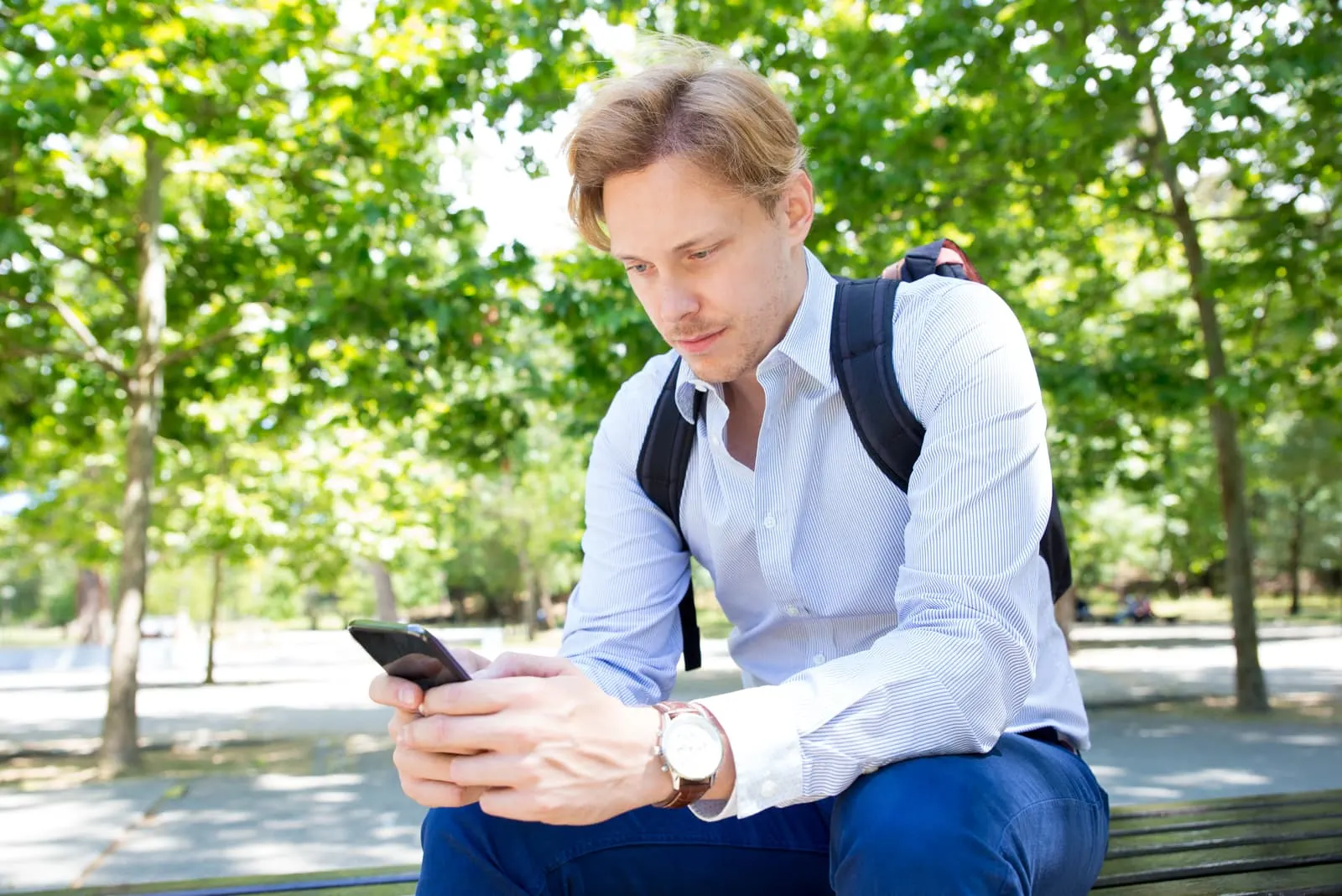 man sitting and holding his phone