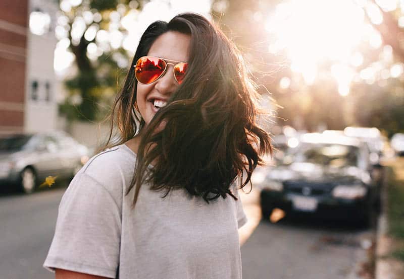 Happy girl with sunglasses walking on the street