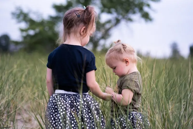 two little girls standing in the field