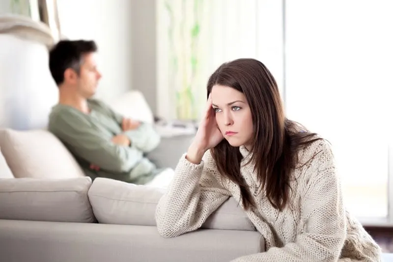 worried woman sitting away from husband