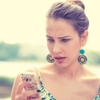 upset woman holding her phone