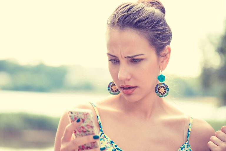 mujer enfadada con el teléfono en la mano
