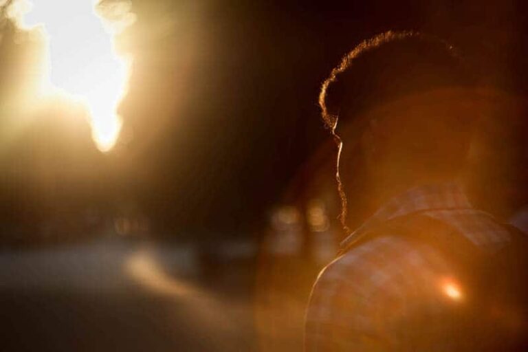 foto de primer plano de hombre con camisa y caminando al aire libre en la puesta de sol