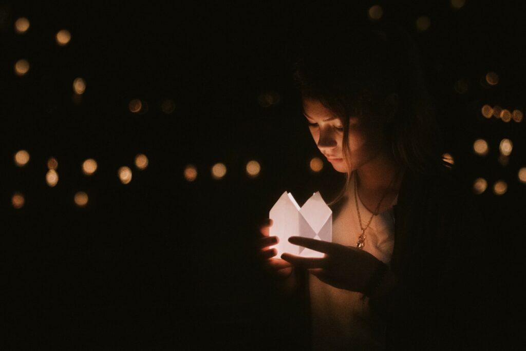 a girl holding a lantern in her hand