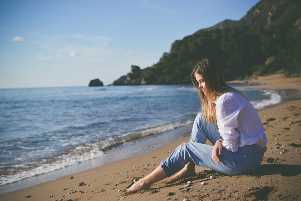 a lonely girl sitting by the sea