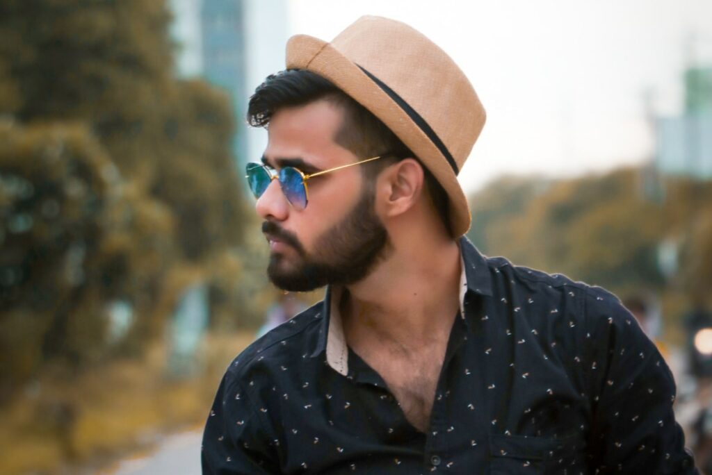 a muscular young man with a hat and glasses