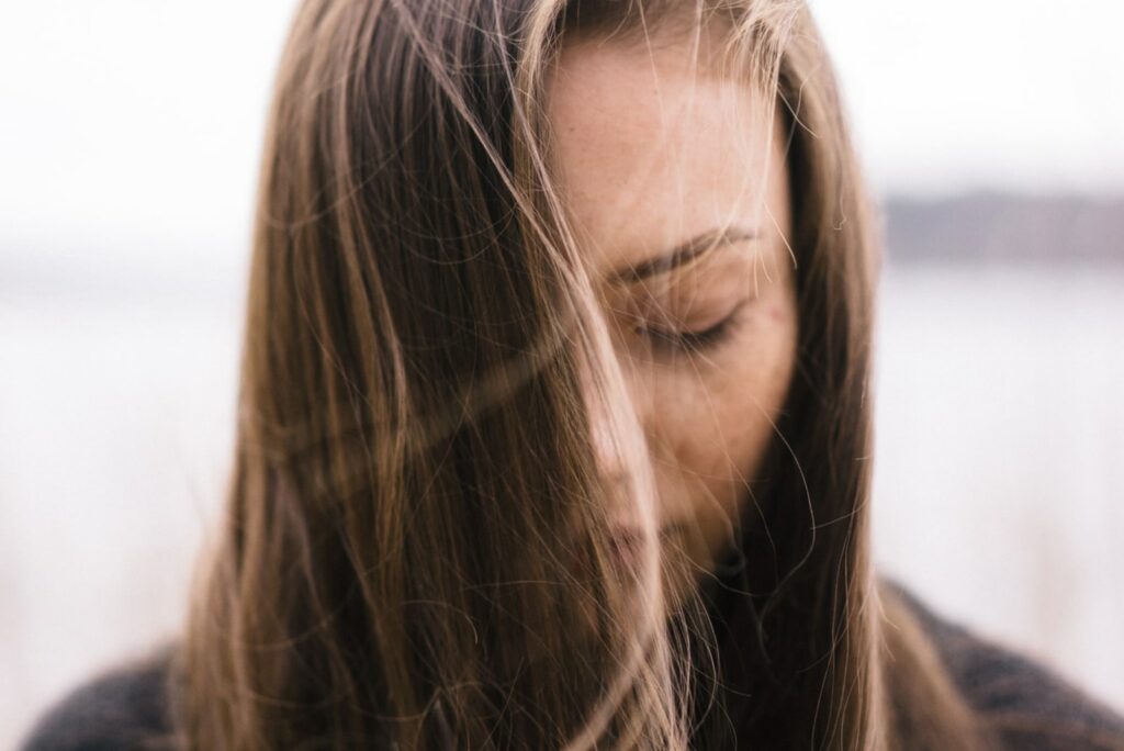 una ragazza triste guarda il pavimento