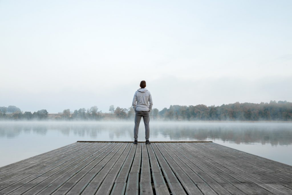 a young man standing alone on the dock