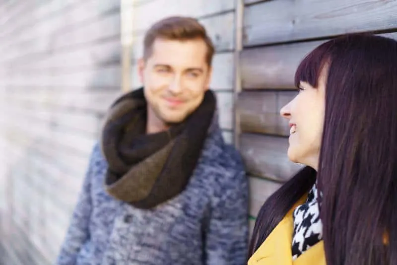 cute woman standing outside looking at man with a warm smile