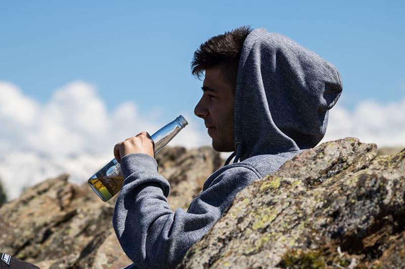 man drinking a beer from bottle