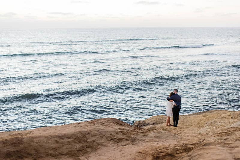 Couple hugging by the ocean