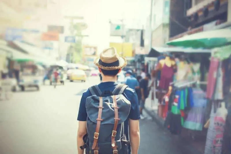 tourist with hat walking through outdoor market