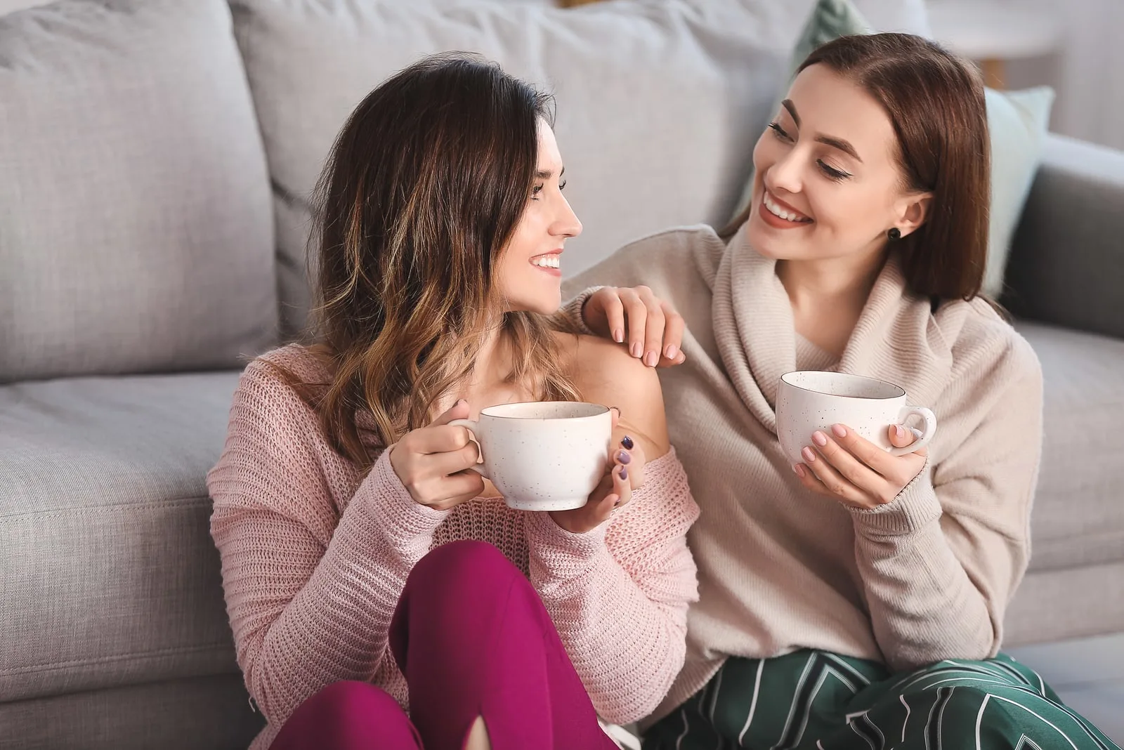two young women talking and drinking coffee
