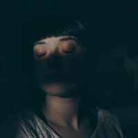 rosto de mulher com os olhos fechados no escuro