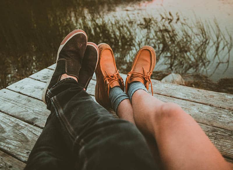 Couple's legs by the water