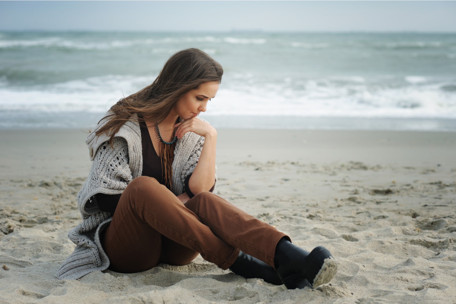 sad woman sitting on the beach