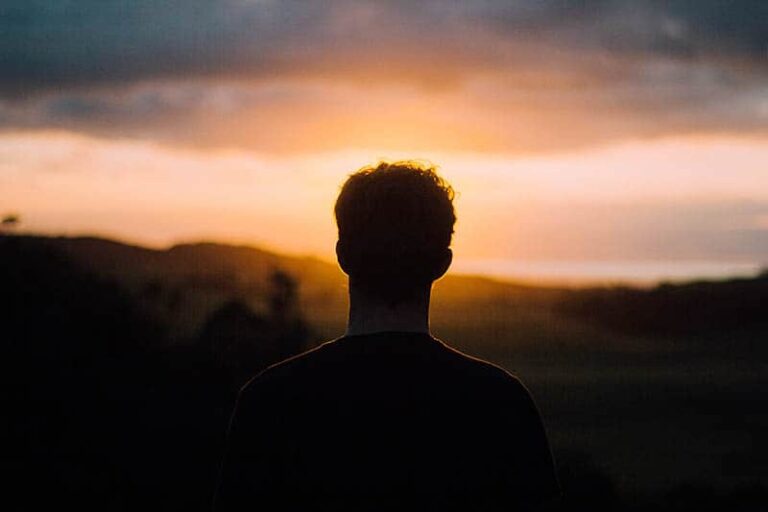 silueta de hombre mirando la puesta de sol
