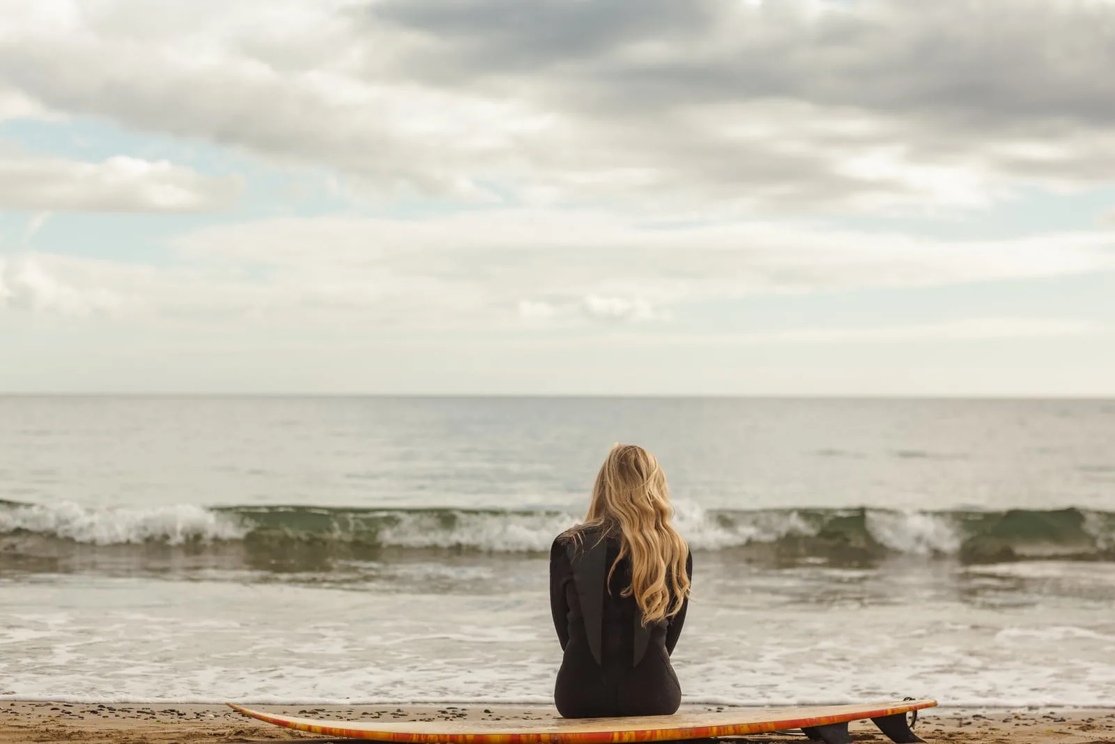 a sad woman sitting by the sea