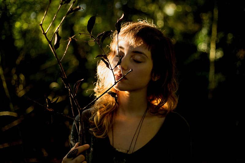 Mujer en la naturaleza sujetando una rama