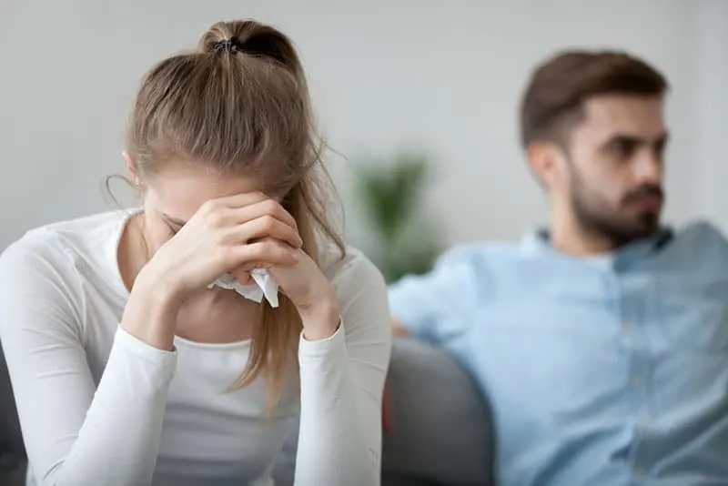 young woman crying while man sitting 