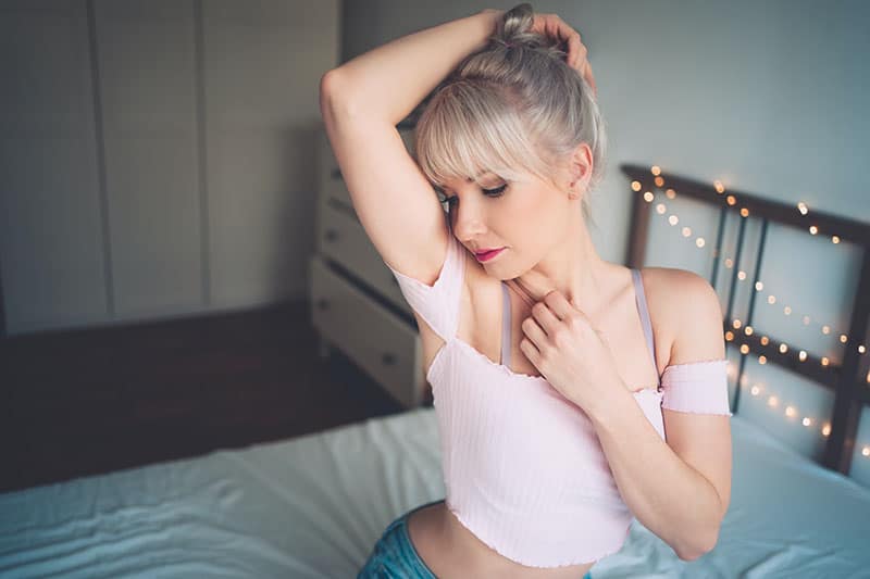 young woman sitting on bed 