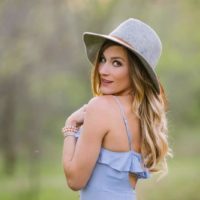 mujer atractiva con vestido azul y sombrero gris